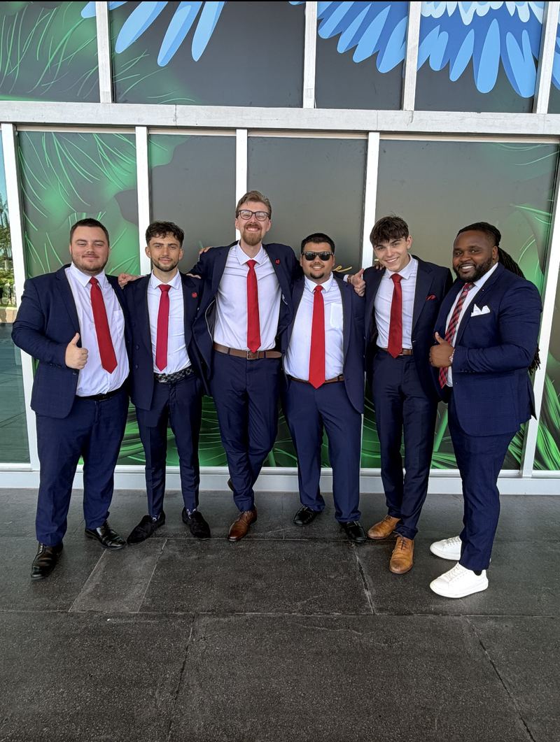 LY Marketing team of six in navy suits and red ties